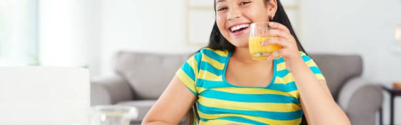 Portrait of a happy young girl enjoying a healthy breakfast at home